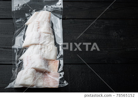 Haddock white fish fillet in plastic market pack, on black wooden table, top view with copy space for text Haddock white fish fillet in plastic market pack, on black wooden table, top view with copy space for text 78565152