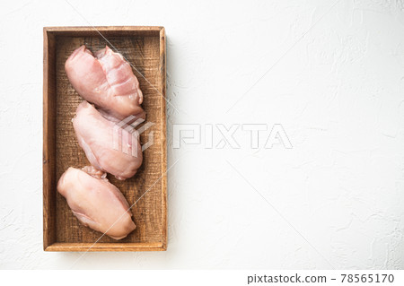 Chicken breast fillets, in wooden box, on white stone background, top view flat lay, with copy space for text 78565170