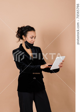 Portrait of black businesswoman wearing face mask during virus epidemic in studio. Portrait of black businesswoman wearing face mask during virus epidemic in studio. 78565766