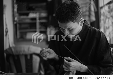 A man sewing 78566643