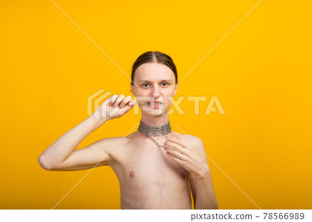 Androgyn young man in men outfit indoors. Studio shot Androgyn young man in men outfit indoors. Studio shot 78566989