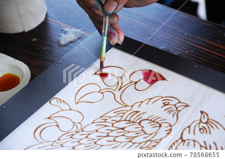 SELANGOR, MALAYSIA -DECEMBER 07, 2016: Malaysian draw batik or batik canting. The color control by wet wax that drawn earlier. SELANGOR, MALAYSIA -DECEMBER 07, 2016: Malaysian draw batik or batik canting. The color control by wet wax that drawn earlier. 78568655