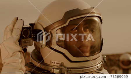 Female astronaut shooting terrain of Mars 78569069