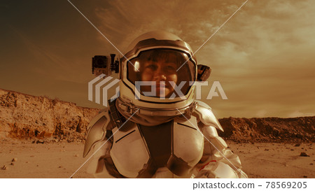 Female astronaut looking at camera on Mars Female astronaut looking at camera on Mars 78569205