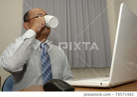 Middle-aged man working on a computer 78571482
