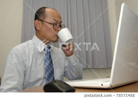 Middle-aged man working on a computer Middle-aged man working on a computer 78571488