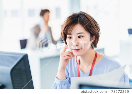 A young business woman using a computer in a bright office 78572229