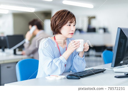 A woman working in the office over coffee A woman working in the office over coffee 78572231