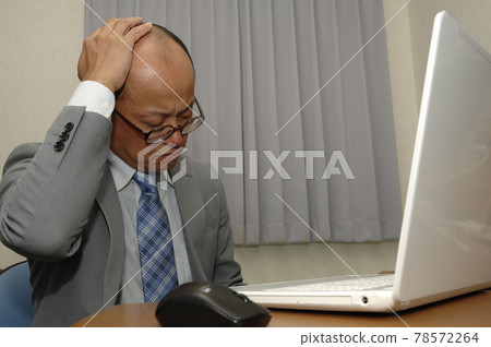 Middle-aged man working on a computer Middle-aged man working on a computer 78572264