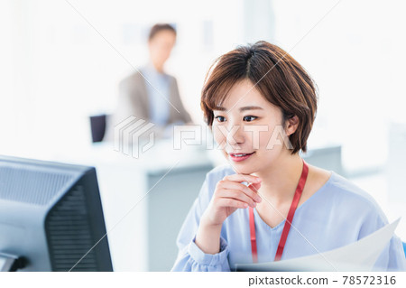 A young business woman using a computer in a bright office 78572316