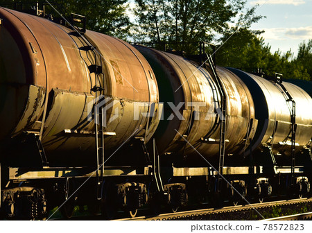 Freight train with petroleum tank cars on railroad. Rail cars carry oil and ethanol. Freight train with petroleum tank cars on railroad. Rail cars carry oil and ethanol. 78572823