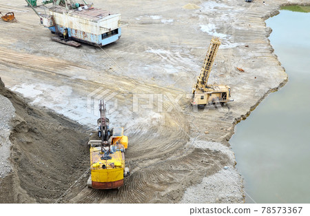 Excavator with electric shovel loading the rocks in mining truck at open pit mine.  78573367