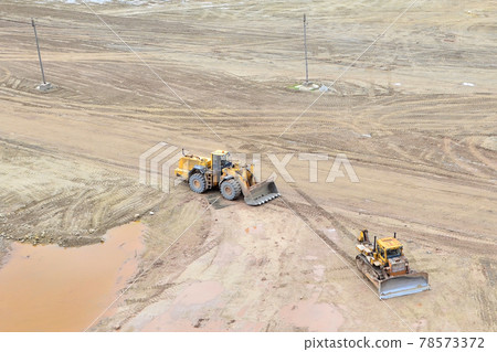 Front loader and bulldozer working in an open pit. Mining industry concept. Drone view Front loader and bulldozer working in an open pit. Mining industry concept. Drone view 78573372
