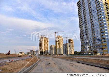 Tower cranes in action at construction site. Tower cranes in action at construction site. 78573373