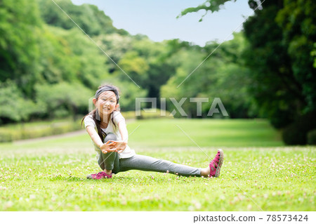 在草坪上伸展的女孩 78573424