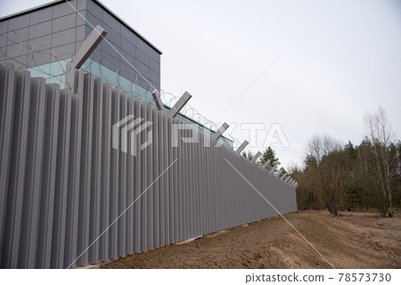 Fence with metal mesh on a background of blue sky 78573730