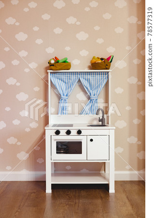 Toy wooden kitchen in a children playroom Toy wooden kitchen in a children playroom 78577319