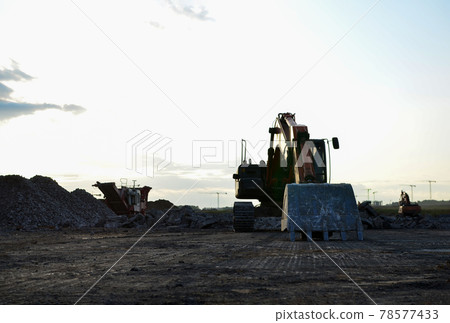 Excavator on destruction of concrete and hard rock at the construction site. Excavator on destruction of concrete and hard rock at the construction site. 78577433
