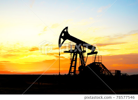 Crude oil pump jack at oilfield on atmospheric sunset backround. Fossil crude output  78577546