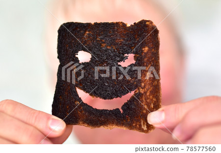 Burnt toast bread slices. Woman holds in hands a burnt slice of toast  78577560