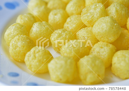 Yellow round corn snacks with cheese flavor Yellow round corn snacks with cheese flavor 78578448