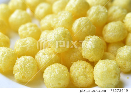 Yellow round corn snacks with cheese flavor 78578449