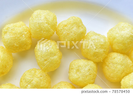 Yellow round corn snacks with cheese flavor Yellow round corn snacks with cheese flavor 78578450