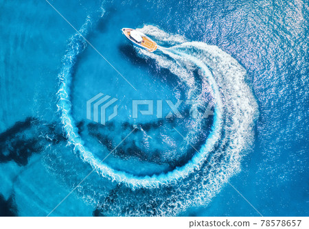 Aerial view of the speed boat in clear blue water at sunny day Aerial view of the speed boat in clear blue water at sunny day 78578657