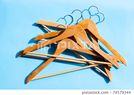 Wooden clothes hangers on blue background 78579344