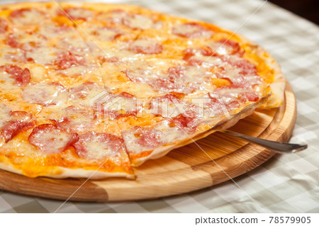 Ready thin delicious pizza on the table in a cafe. Ready thin delicious pizza on the table in a cafe. 78579905