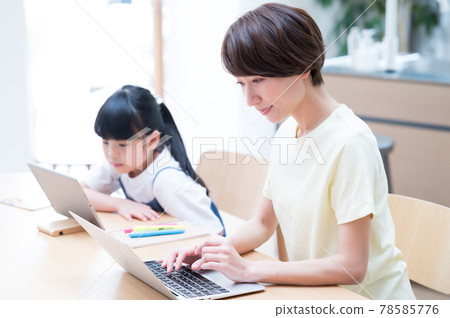 Mother teleworking next to a girl learning online 78585776
