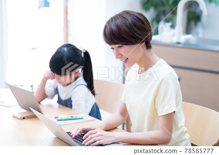 Mother teleworking next to a girl learning online 78585777