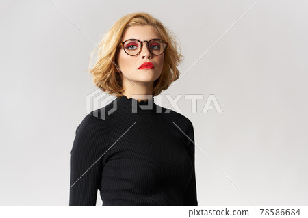 Blonde girl with glasses red lips black blouse cropped view glamor light background studio Blonde girl with glasses red lips black blouse cropped view glamor light background studio 78586684