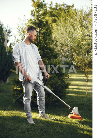 Lawn mower man working on the backyard Lawn mower man working on the backyard 78587133