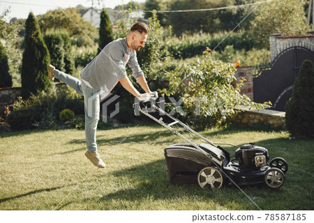 Lawn mower man working on the backyard Lawn mower man working on the backyard 78587185