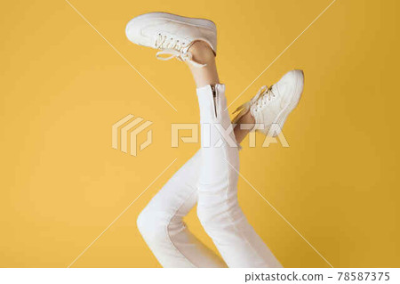 inverted legs in white sneakers fashion modern style yellow background inverted legs in white sneakers fashion modern style yellow background 78587375