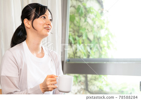 一位穿著夏季羊毛衫的女士喝杯咖啡休息一下 一位穿著夏季羊毛衫的女士喝杯咖啡休息一下 78588284