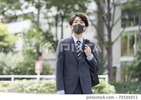 A young businessman wearing a dark gray mask 78588851