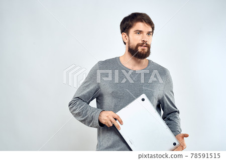 Emotional man holding a laptop success modern style work light background 78591515