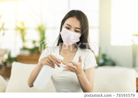 Young woman working at home, wearing a mask Young woman working at home, wearing a mask 78593579