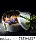 food photography of romantic gift box side view with homemade cookies with cinnamon and flowers on a dark background close up  78594837