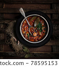 red traditional german tomato soup top view with meat products, beans, herbs on a brown wooden texture background closeup. First course. Selective focus 78595153