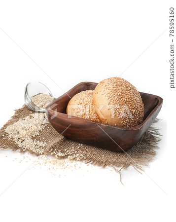 fresh wheat buns with sesame seeds in brown wooden plate side view on white background isolated closeup. Selective focus 78595160