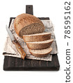 food photography of sliced loaf of rye bread side view on brown wooden board on white isolated background close up 78595162