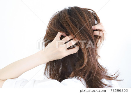 A woman touching her hair A woman touching her hair 78596803