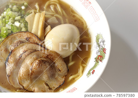 A bird's-eye view of hot pork bone soy sauce ramen with roasted char siu, taste balls, menma and all-purpose green onions on a white background A bird's-eye view of hot pork bone soy sauce ramen with roasted char siu, taste balls, menma and all-purpose green onions on a white background 78597380