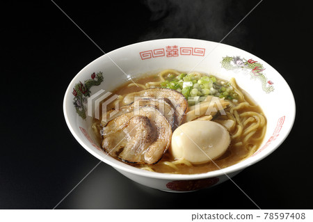 Photographed hot pork bone soy sauce ramen with roasted char siu, taste balls, menma and all-purpose green onions on a black background 78597408