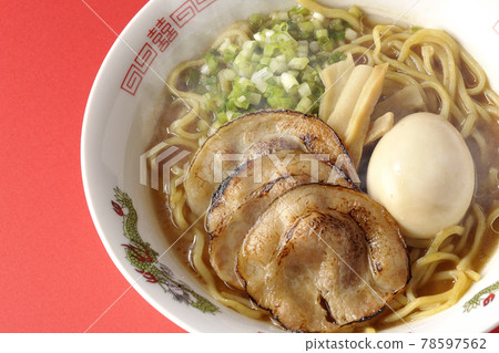 A bird's-eye view of hot pork bone soy sauce ramen with roasted char siu, taste balls, menma and all-purpose green onions on a red background A bird's-eye view of hot pork bone soy sauce ramen with roasted char siu, taste balls, menma and all-purpose green onions on a red background 78597562