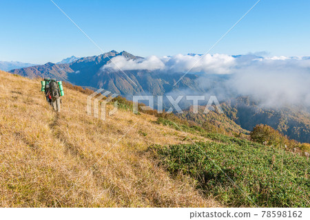 Hikers walk in the mountains at sunset. 78598162