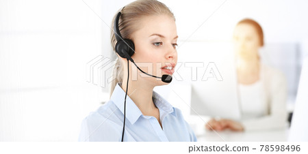 Blond woman working in sunny call center. Group of diverse people working as customer service occupation. Business concept Blond woman working in sunny call center. Group of diverse people working as customer service occupation. Business concept 78598496